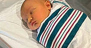 Kayleigh joined the competition — help win amazing prizes! newborn, baby, sleeping, hospital, bassinet, blanket, striped_blanket, infant, wrapped, peaceful, bed, metal_rails, white_bedding, cute, child, portrait, indoors, resting, human, swaddled