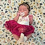 Nariah Alaia Rene' is registered to the contest to win money with this photo: baby, newborn, sleeping, pacifier, headband, dress, skirt, booties, blanket, floral_pattern, infant, cute, soft_texture, peaceful, small_hands, lying_down, indoors, portrait, child, adorable