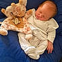 baby, newborn, sleeping, plush_toy, giraffe, pacifier, blanket, blue, white_clothing, infant, cozy, cute, soft, resting, child, indoor, peaceful, comfort, cuddly, portrait