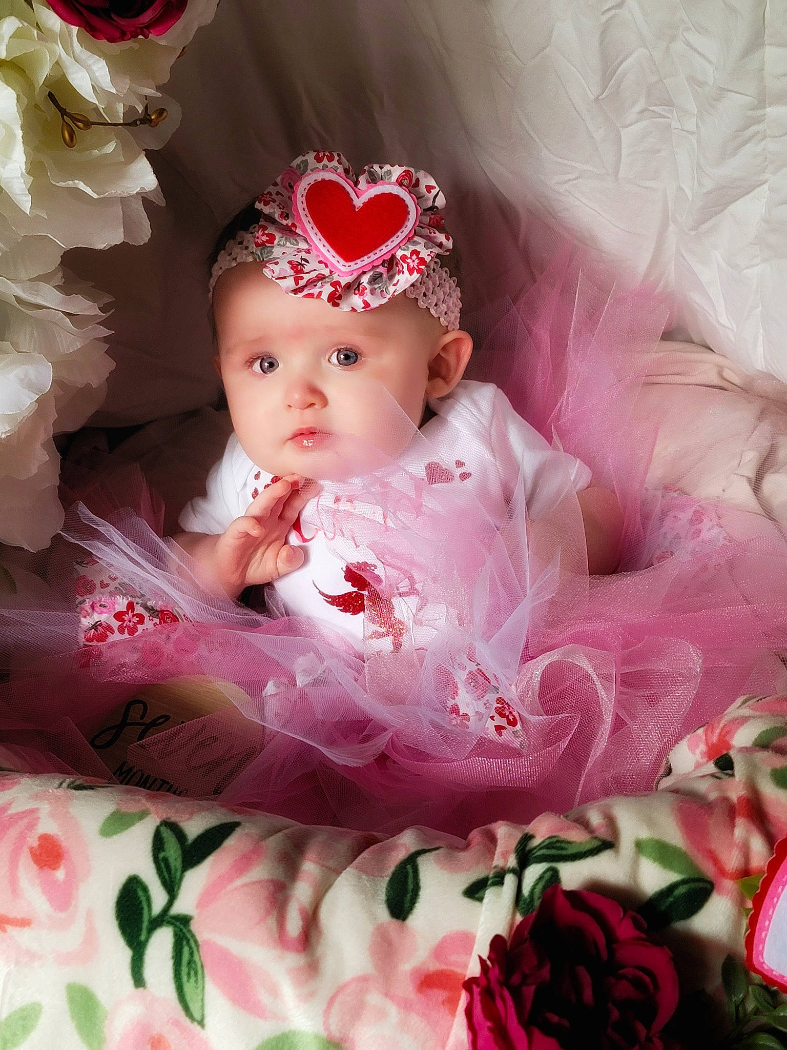 Stella is registered to the contest to win money with this photo: baby, baby_products, baby_toddler_clothing, cheek, child, dress, embellishment, eyelash, face, hair_accessory, headband, headpiece, headwear, iris, magenta, pattern, person, petal, pink, skin