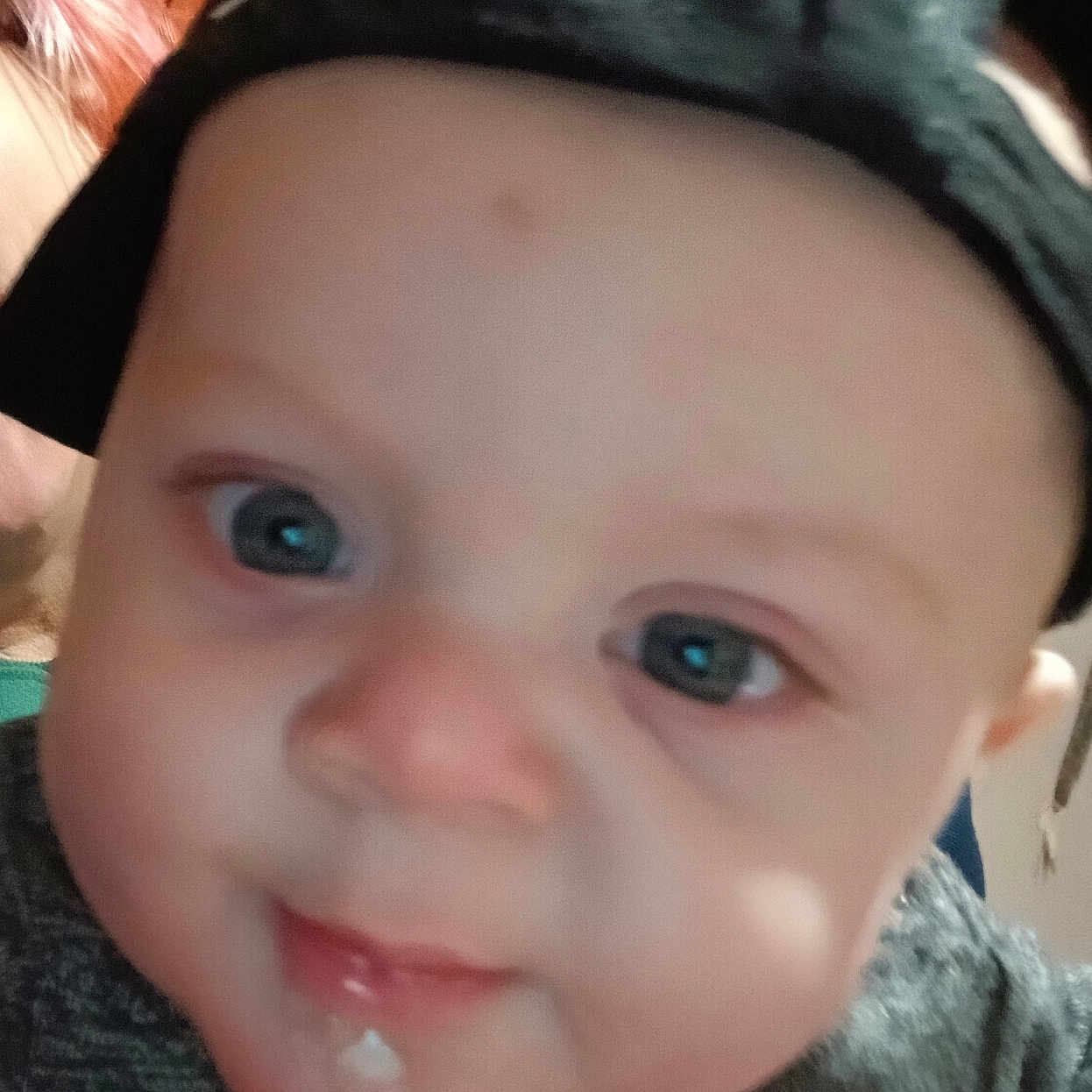 Jordan is registered to the contest to win money with this photo: baby, blue_eyes, cap, casual, child, closeup, clothing, curious, drool, expression, face, hand, headwear, human, indoor, infant, person, portrait, skin, young