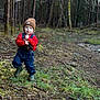 child, toddler, beanie, brown_hat, red_sweater, denim_overalls, rubber_boots, forest, trees, moss, grass, dirt, outdoors, nature, portrait, person, blue_eyes, rosy_cheeks, standing, walking