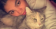 Rocksie Russell joined the competition — help win amazing prizes! person, cat, pet, cuddling, bed, bedroom, blanket, pillow, sleeping, lying_down, portrait, face, eyes, whiskers, fur, gray_cat, cozy, indoors, warm_lighting, relaxing