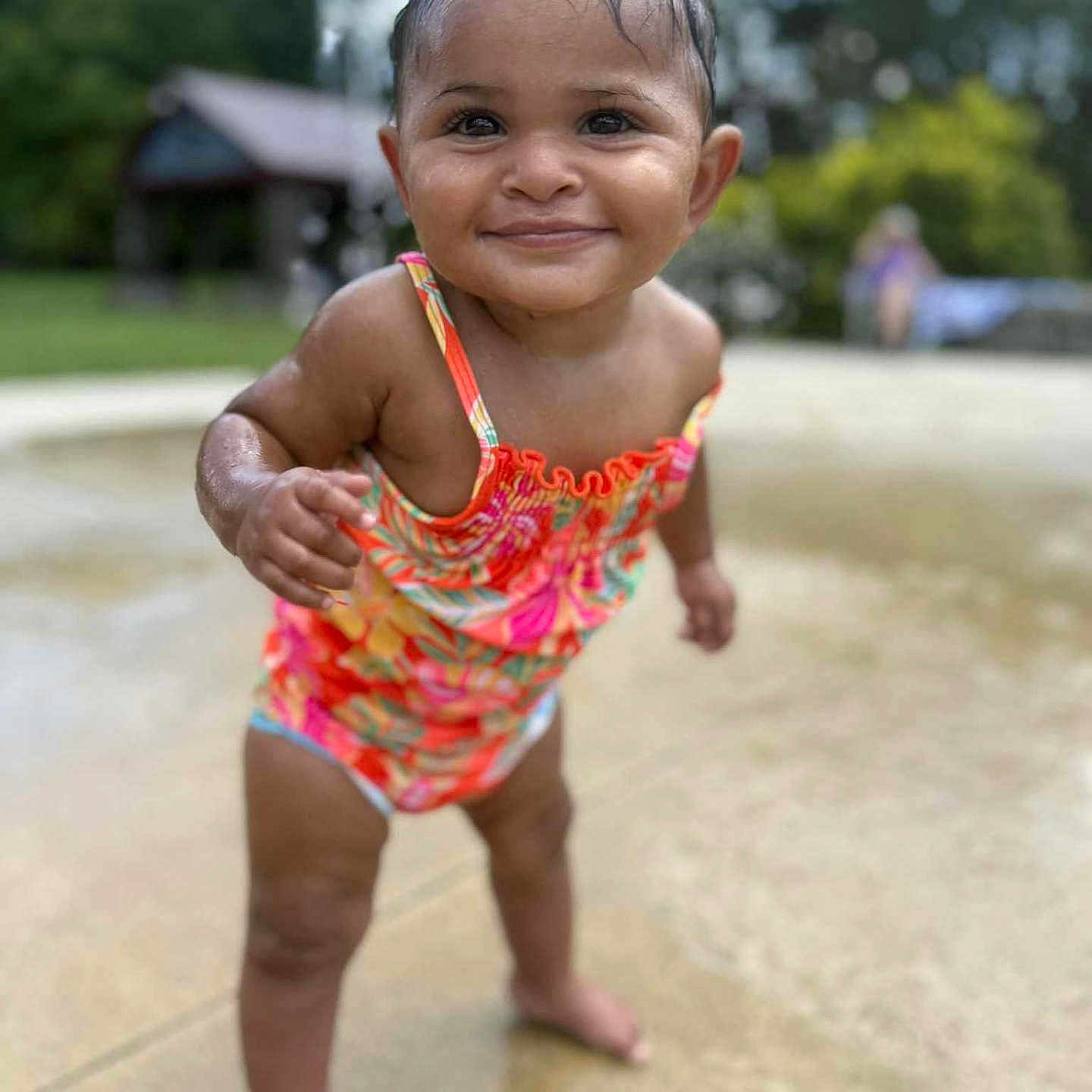 Maizie joined the competition — help win amazing prizes! background, child, daylight, face, fun, hair, happy, nature, outdoor, park, person, playful, skin, smiling, standing, summer, swimsuit, toddler, water, wet