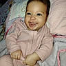 Victoria is registered to the contest to win money with this photo: baby, child, infant, smiling, happy, portrait, indoors, bed, blanket, pajamas, pink_clothing, sitting, lying_down, face, hands, dark_hair, cozy, home, photography, joy
