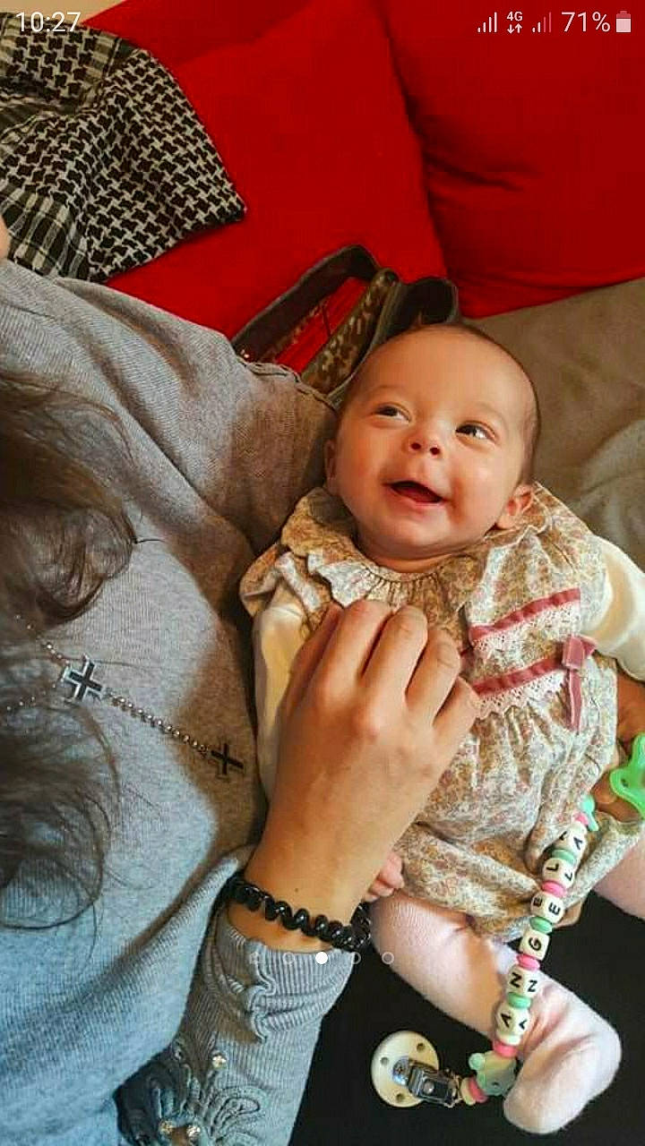 Angéla participe au concours pour gagner de l'argent avec cette photo : arm, baby, baby_toddler_clothing, cheek, child, comfort, event, finger, gesture, hand, happy, jewellery, mouth, nail, person, sitting, skin, smile, thumb, toddler