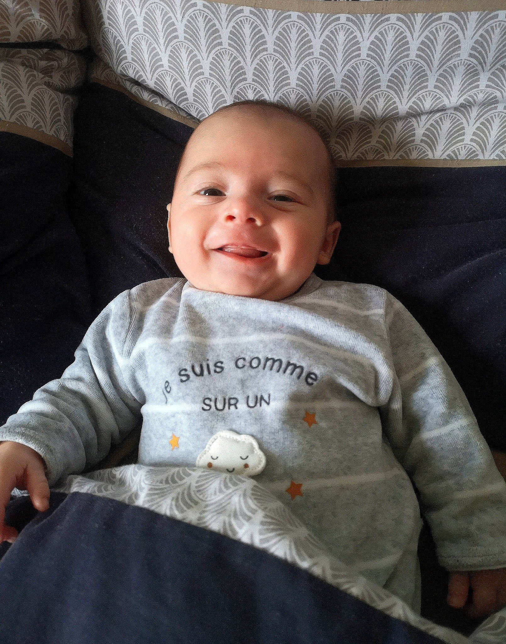 Jules participe au concours pour gagner de l'argent avec cette photo : baby_toddler_clothing, cheek, clothing, comfort, couch, facial_expression, grey, hairstyle, happy, iris, joy, living_room, mammal, nose, person, product, skin, sleeve, smile, t_shirt