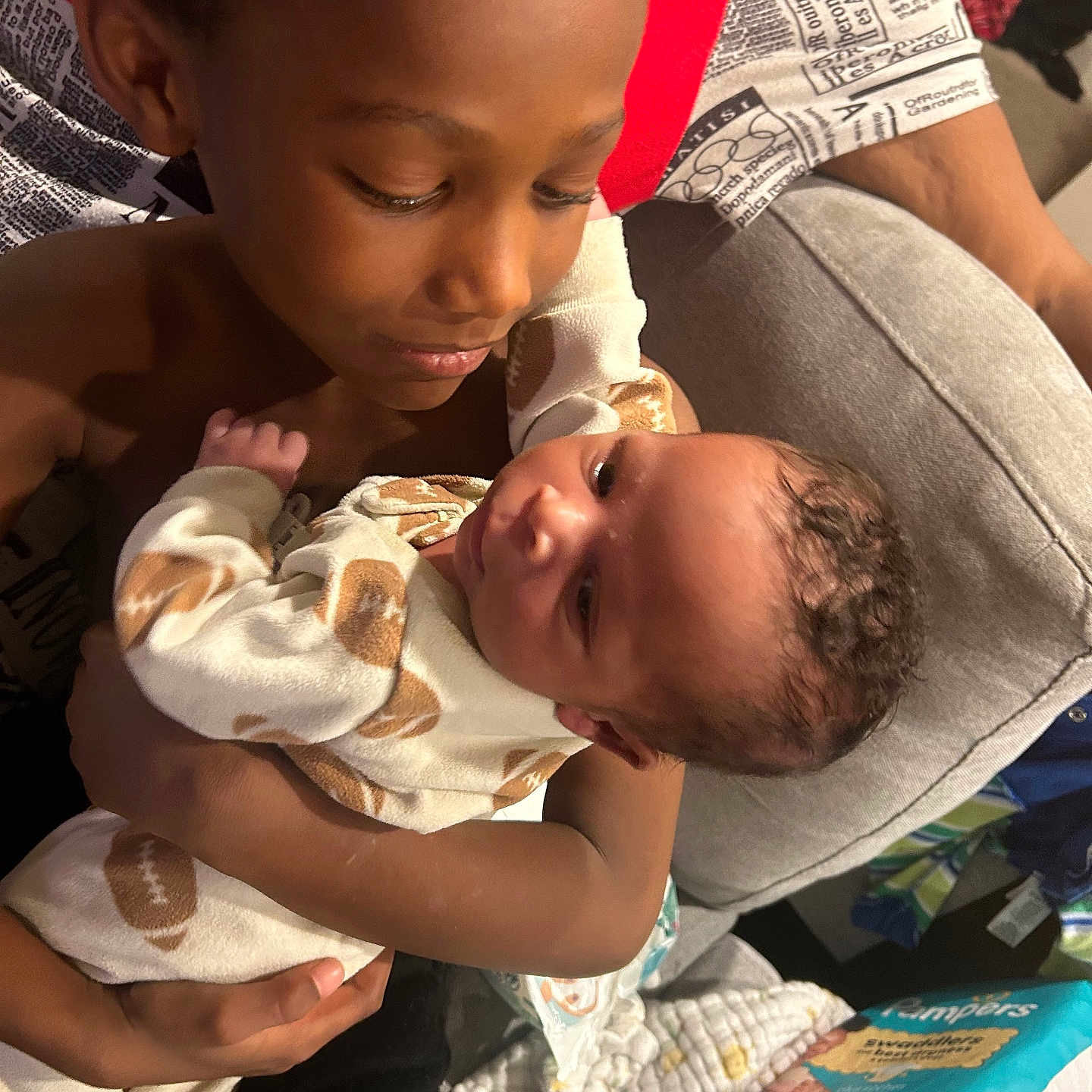 Cortez joined the competition — help win amazing prizes! baby, blanket, child, clothing, comfort, couch, cute, diapers, face, family, holding, home, indoor, infant, newborn, person, pillow, sibling, smiling, tender