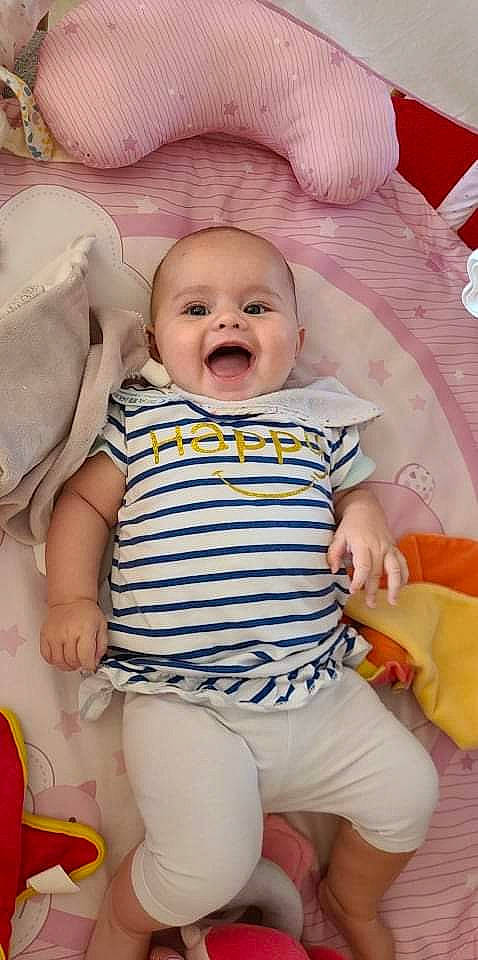 Lola participe au concours pour gagner de l'argent avec cette photo : baby, baby_toddler_clothing, cheek, child, comfort, face, facial_expression, fun, happy, human, iris, pattern, person, photograph, pink, skin, sleeve, smile, textile, toddler