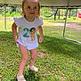 toddler, child, outdoor, grass, playground, trampoline, white_clothing, smiling, curious, shoes, short_hair, sunlight, greenery, young_child, happy, summer, nature, play, person, cute