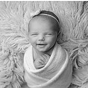 Tianna joined the competition — help win amazing prizes! newborn, baby, smiling, headband, bow, blanket, wrapped, sleepy, cozy, soft_texture, black_and_white, portrait, infant, cute, peaceful, hands, face, resting, closeup, studio