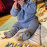 Sacha participe au concours pour gagner de l'argent avec cette photo : baby, child, blue_outfit, chewing, toy, wooden_puzzle, name_puzzle, indoor, play_mat, floor, couch, chair, curious, cute, person, infant, smiling, home, childhood, playtime