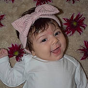 Millie joined the competition — help win amazing prizes! baby, child, smile, headband, pink, flower, flowers, blanket, soft, happy, portrait, infant, cute, lying_down, white_clothing, closeup, cheerful, face, young, indoors