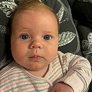 Jaime is registered to the contest to win money with this photo: baby, blue_eyes, child, closeup, couch, cozy, cushion, expression, face, hand, indoor, infant, newborn, onesie, person, portrait, resting, skin, soft_lighting, striped_clothing