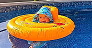 Kameron joined the competition — help win amazing prizes! baby, pool, inflatable_ring, water, swimming, child, hooded_swimsuit, summer, outdoor, sunlight, blue_water, floating, playful, vacation, fun, bright_colors, nature, house, trees, recreation