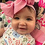 baby, child, pink_bow, smiling, face, flower_pattern, clothing, seat, minnie_mouse, cartoon, headband, cute, infant, portrait, closeup, happy, indoor, person, baby_girl, colorful