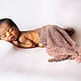 newborn, baby, sleeping, blanket, knitted, soft, white_background, peaceful, infant, skin, face, portrait, resting, cute, young, child, lying_down, cozy, warm, serene