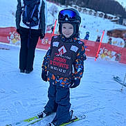 Isaac a rejoint le concours — aidez-le/la à gagner de superbes lots ! child, skiing, snow, winter_clothing, helmet, goggles, ski_equipment, outdoor, mountain, snow_sport, gloves, jacket, pants, ski_school, smiling, person, cold_weather, recreational_activity, fun, snowy_landscape