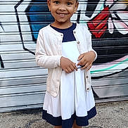 Aurore a rejoint le concours — aidez-le/la à gagner de superbes lots ! cardigan, casual, child, colorful, concrete, dress, earrings, fashion, girl, graffiti, happy, outdoor, person, portrait, sandals, smiling, standing, street, urban, young