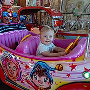 Darius-Daniel participe au concours pour gagner de l'argent avec cette photo : child, toddler, amusement_ride, kiddie_car, smiling, indoor, colorful, cartoon_art, toy_car, playful, blue_eyes, short_hair, entertainment, fun, amusement_park, seat, hand_on_wheel, face, happy, clothing