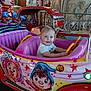 child, toddler, amusement_ride, kiddie_car, smiling, indoor, colorful, cartoon_art, toy_car, playful, blue_eyes, short_hair, entertainment, fun, amusement_park, seat, hand_on_wheel, face, happy, clothing