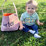 Carter joined the competition — help win amazing prizes! toddler, child, grass, outdoor, smile, jeans, socks, shirt, duck, bag, sunlight, greenery, happy, cute, portrait, nature, baby, feet, casual_clothing, sitting