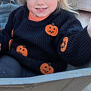 Ava joined the competition — help win amazing prizes! child, girl, sweater, pumpkin, halloween, wheelbarrow, outdoor, blonde_hair, pigtails, orange_bows, smiling, cute, fall, decorations, wooden_background, playful, young_child, knitwear, festive, costume