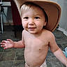 toddler, child, diaper, cowboy_hat, smiling, indoor, floor, tile, bare_chest, cute, young_child, person, hat, playing, happy, home, furniture, curious, expression, casual