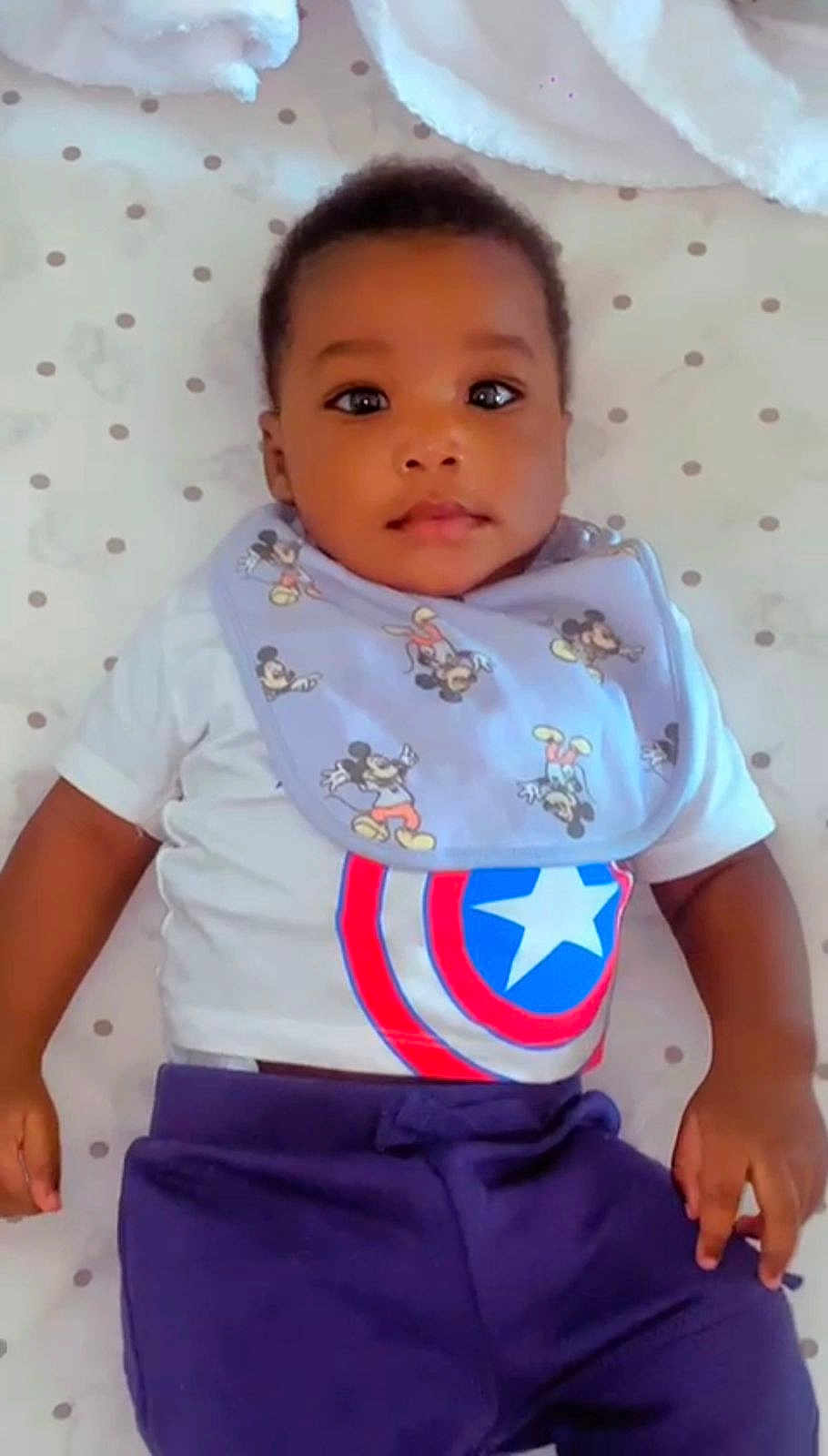 Abner Maria a rejoint le concours — aidez-le/la à gagner de superbes lots ! baby, child, toddler, infant, mickey_mouse, bib, tshirt, captain_america, polka_dot, bedspread, clothing, face, hands, lying_down, portrait, cute, indoor, young_child, casual_wear, baby_girl_or_boy