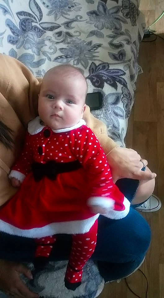 Hayley a rejoint le concours — aidez-le/la à gagner de superbes lots ! baby, baby_toddler_clothing, child, day_dress, doll, dress, event, facial_expression, human_leg, lip, outerwear, pattern, person, pink, sitting, skin, sleeve, sock, thigh, toddler