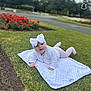 baby, child, blanket, grass, headband, outdoor, flower_bed, greenery, cute, infant, person, nature, park, soft_texture, white_clothing, pink_pants, smiling, toddler, daylight, portrait