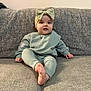 Willow is registered to the contest to win money with this photo: baby, child, headband, bow, couch, sofa, gray, clothing, sitting, foot, indoor, person, infant, cute, comfortable, casual, portrait, young, home, relaxed