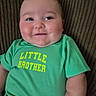 Levi is registered to the contest to win money with this photo: baby, child, infant, smiling, portrait, close_up, green_shirt, text_on_clothing, little_brother, striped_background, chair, sitting, indoors, face, eyes, cheeks, short_sleeves, casual_clothing, happy, photograph
