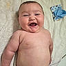 Levi is registered to the contest to win money with this photo: baby, infant, child, smiling, laughing, portrait, lying_down, bare_chested, towel, blanket, blue_cloth, patterned_fabric, indoors, close_up, face, eyes, mouth, happy, skin, photography