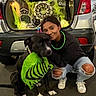 bandana, black_dog, car, celebration, cobweb, costume, decoration, dog, festive, halloween, jeans, light, night, outdoor, person, skull, smile, sneakers, street, trunk