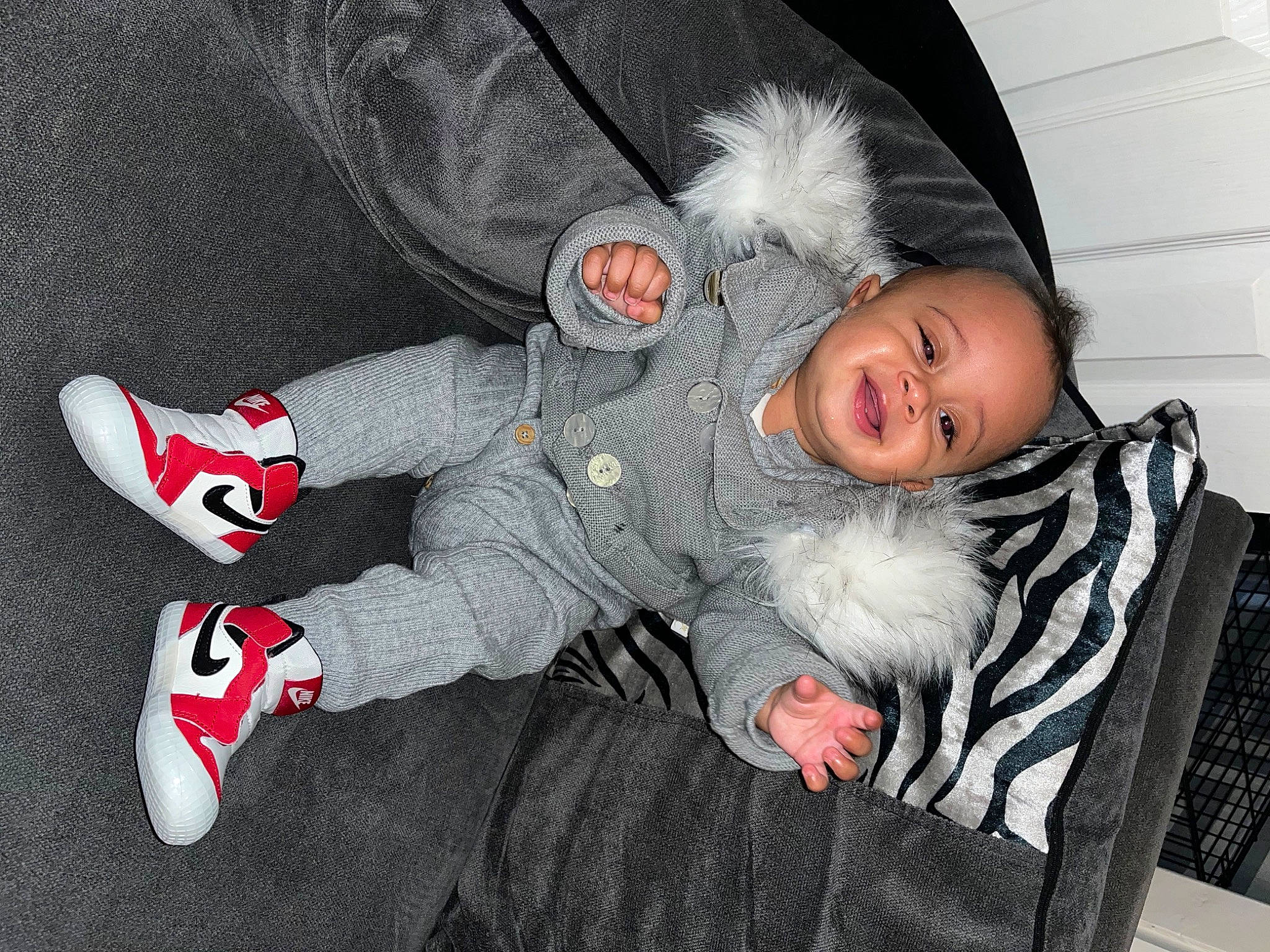 Marcel-batou is registered to the contest to win money with this photo: baby, baby_toddler_clothing, carmine, child, comfort, eye, fun, fur, grey, lap, pattern, person, sitting, sleeve, smile, toddler