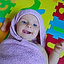 baby, blue_eyes, bright_colors, child, colorful_mat, cute, foam_puzzle, hand, happy, head, indoors, infant, lying_down, playful, skin, smiling, soft_texture, tongue_out, towel, wrapped