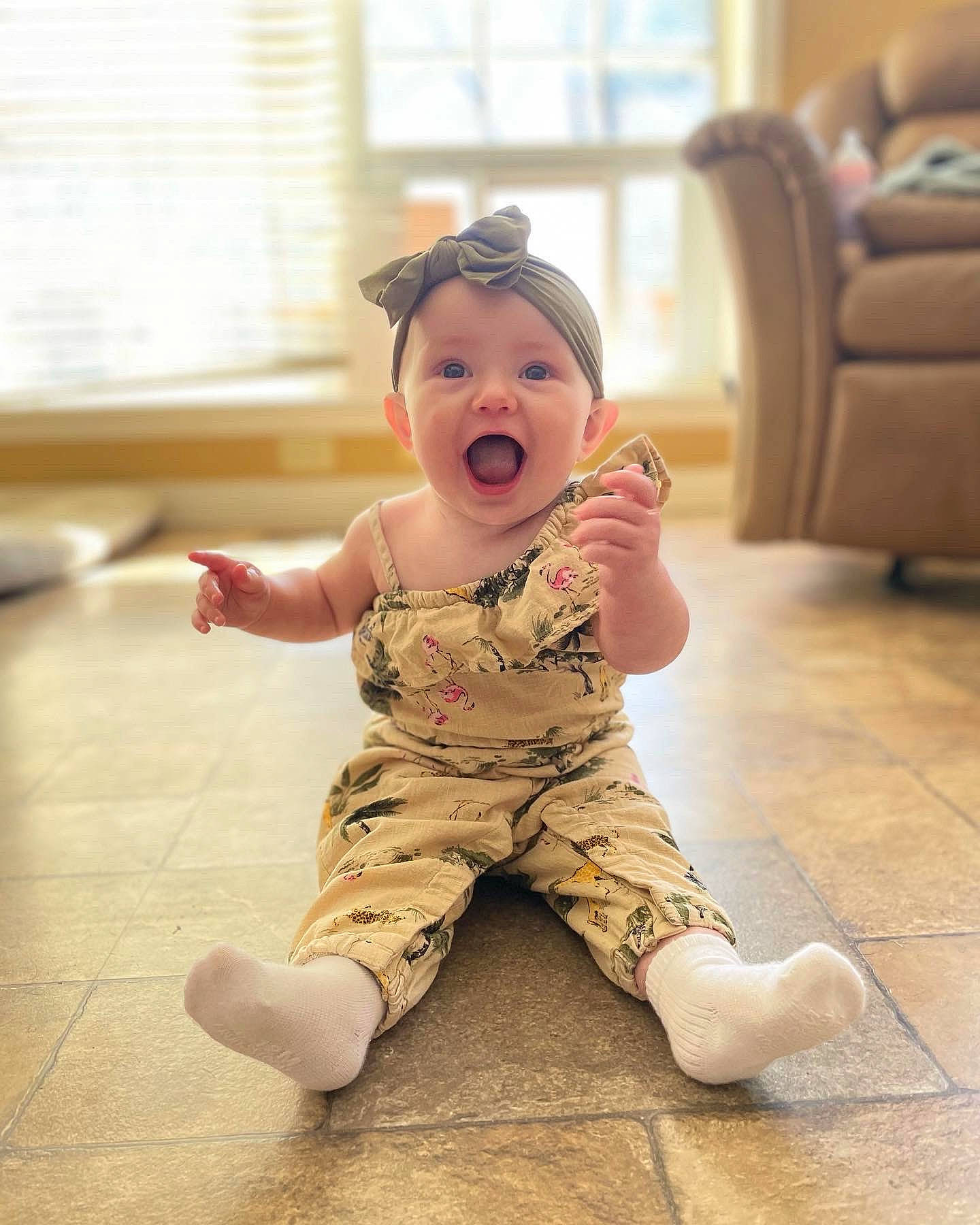 Adelynn joined the competition — help win amazing prizes! baby, baby_toddler_clothing, chair, cheek, child, eye, face, floor, flooring, foot, fun, happy, hardwood, head, human_leg, person, sleeve, smile, surprise, toddler