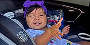 Nazneen joined the competition — help win amazing prizes! toddler, child, car_seat, purple_headband, white_dress, embroidery, car_interior, window, seatbelt, bottled_water, playful, smiling, person, young_child, baby, seat, safety, happy, cute, indoors