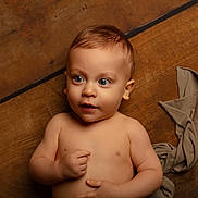 Alessio a rejoint le concours — aidez-le/la à gagner de superbes lots ! baby, infant, child, big_eyes, blue_eyes, bare_torso, lying_down, wooden_floor, fabric_wrap, portrait, studio_lighting, soft_skin, short_hair, curious_expression, hand_on_chest, ear, face, adorable, neutral_background, newborn