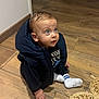 Alessio participe au concours pour gagner de l'argent avec cette photo : child, baby, infant, blue_eyes, puffy_jacket, sitting, wooden_floor, socks, indoors, portrait, curious, cute, hand, doorway, floor_mat, clothing, face, hair, expression, footwear
