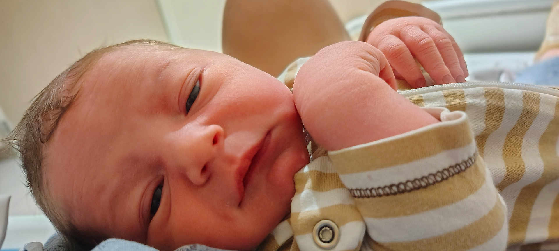 Dallas joined the competition — help win amazing prizes! baby, newborn, infant, face, hand, striped_clothing, close_up, skin, person, sleepy, portrait, young_child, cute, small_hand, soft_light, indoors, resting, newborn_clothes, baby_outfit, human