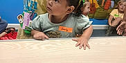 Everly is registered to the contest to win money with this photo: child, children, girl, table, name_tag, classroom, backdrop, mountains, signpost, camping_theme, indoor, playful, curious, hairstyle, ponytail, colorful, kids, education, learning, group