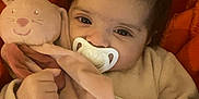 Milhane a rejoint le concours — aidez-le/la à gagner de superbes lots ! baby, pacifier, plush_toy, blanket, soft_toy, infant, cute, child, sleepwear, hand, face, indoors, comfort, warm, resting, expression, closeup, portrait, cuddly, orange_background