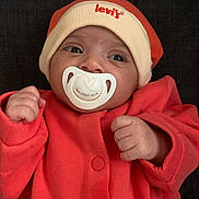 Milhane participe au concours pour gagner de l'argent avec cette photo : baby, infant, pacifier, orange_clothing, hat, face, hands, cute, newborn, child, portrait, indoor, apparel, headwear, expression, person, skin, young, lying_down, cozy