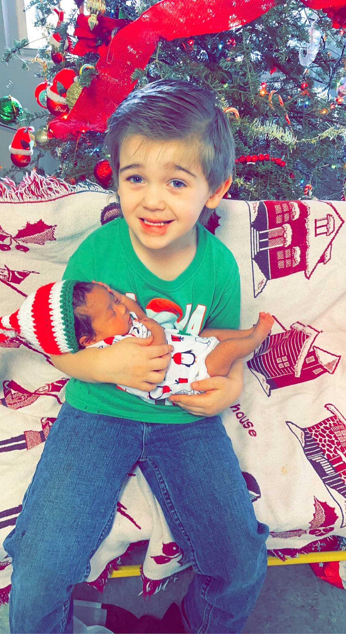 Novaleigh is registered to the contest to win money with this photo: baby, baby_toddler_clothing, child, christmas, christmas_decoration, christmas_ornament, christmas_tree, event, fun, happy, head, holiday, human_body, joy, lap, person, red, sleeve, smile, t_shirt