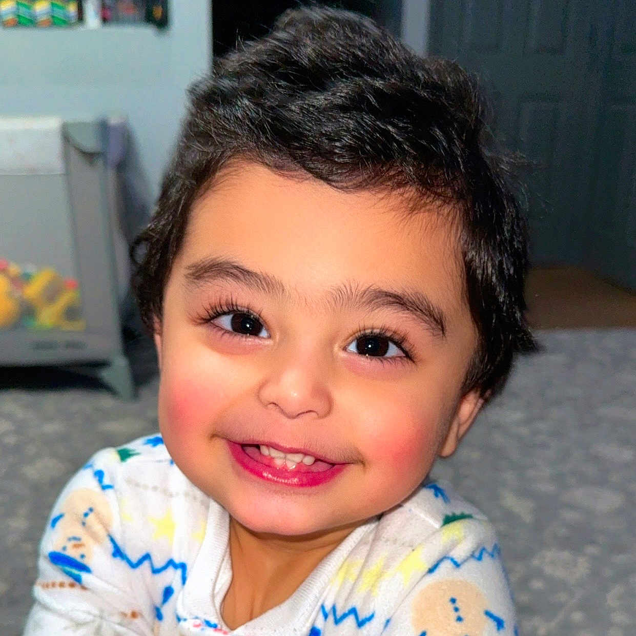 Sultan is registered to the contest to win money with this photo: baby, child, cozy, cute, expression, eyes, face, floor, hair, happy, indoors, infant, pajamas, person, playroom, portrait, rosy_cheeks, smile, toddler, warm_lighting