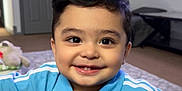Sultan joined the competition — help win amazing prizes! child, toddler, smiling, blue_shirt, adidas, indoor, living_room, carpet, face, happy, person, casual_clothing, couch, home, cute, young_child, portrait, short_hair, buttoned_shirt, bright_eyes