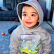 Sultan joined the competition — help win amazing prizes! toddler, child, hoodie, smiling, indoor, living_room, carpet, sofa, toy, face, person, clothing, cute, happy, young_child, casual, portrait, sweatshirt, playful, home