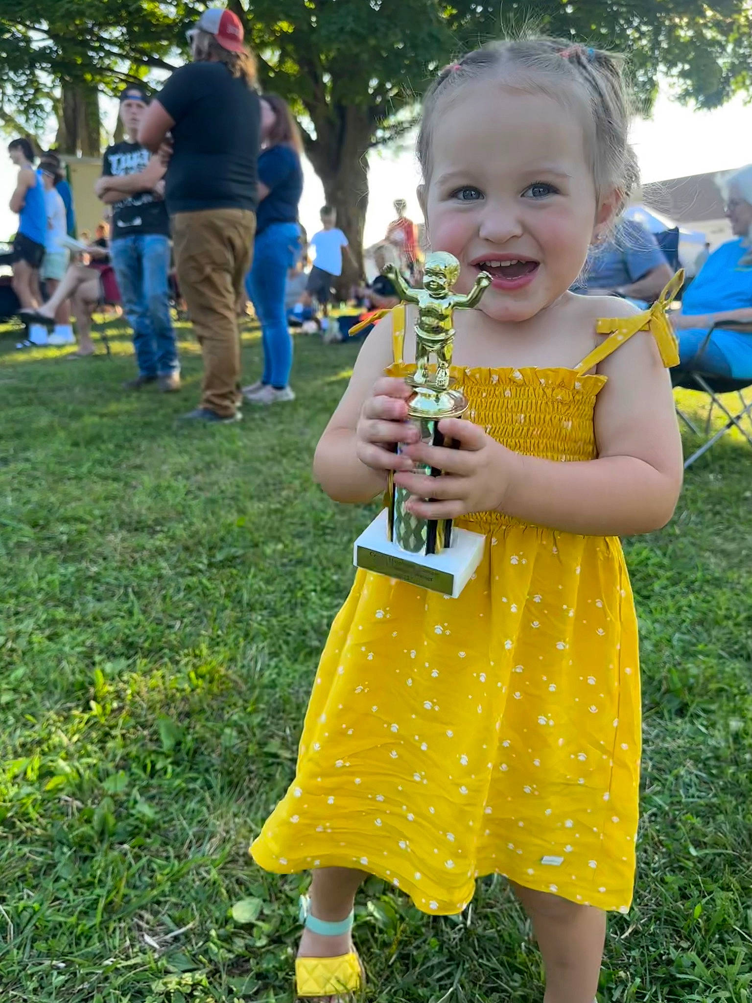 Sophie is registered to the contest to win money with this photo: baby_toddler_clothing, blue, child, event, fun, gesture, grass, grass_family, green, happy, joy, lawn, leisure, people_in_nature, person, plant, smile, summer, thumb, toddler